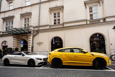 Krakow, Polonya - 8 Temmuz 2025: İki modern lüks Mercedes Benz S63 AMG ve Lamborghini Urus arabaları Polonya 'nın Krakow kentindeki zarif bir Avrupa binasının önünde park halindedir.