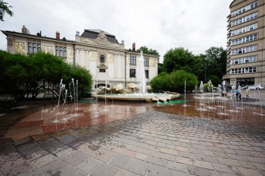 Krakow, Polonya - 08 Temmuz 2025: Bulutlu bir günde Polonya 'nın Krakow kentindeki tarihi Jan Matejko mimarisinin ortasındaki sevimli bir çeşme.
