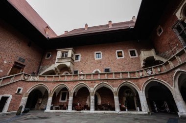 Krakow, Polonya - 08 Temmuz 2025: Polonya 'nın Krakow kentinde bulunan tarihi tuğla cephesi ve kemerleriyle güzel Collegium Maius avlusu