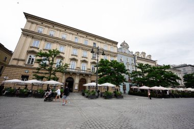 Krakow, Polonya - 08 Temmuz 2025: Polonya 'nın Krakow kentindeki büyüleyici şehir manzarası, tarihi binalar ve canlı açık hava kafeleri sergileniyor.