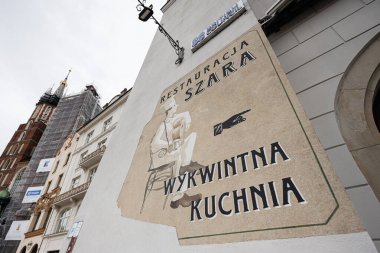 Krakow, Polonya - 08 Temmuz 2025: Polonya 'nın tarihi Krakow kentindeki Szara restoran reklamını resmeden bir sokak resmi.