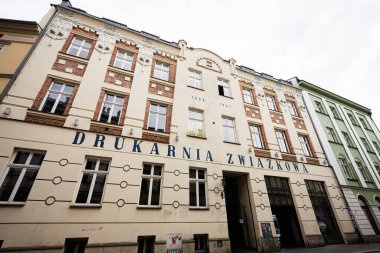 Krakow, Polonya - 08 Temmuz 2025: Bulutlu bir günde Polonya 'nın Krakow kentinde geleneksel bir kırmızı tuğla mimari cephesi Drukarnia Zwizkowa.