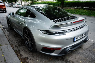 Krakow, Polonya - 08 Temmuz 2025: Üst düzey gümüş spor Porsche 992 911 Turbo S arabası Krakow, Polonya 'da park halinde, parlak bir tasarım sergileniyor..