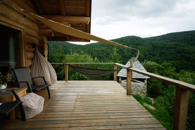 Doğal manzaralı, rahat ahşap bir güverte, bir hamak ve rahatlatıcı mobilyalar..