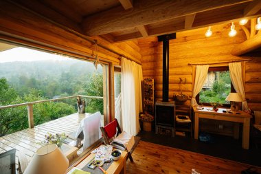 Kırsal ahşap bir kulübe, parlak bir dekor ve manzaralı bir açık hava manzarası..