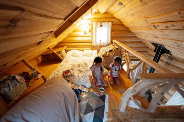 Çocuklar büyüleyici kırsal bir ahşap çatı katında doğal ışığın tadını çıkarıyorlar..