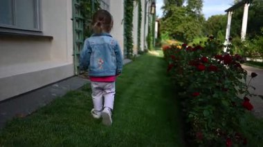 Mutlu bir çocuk Polonya 'nın Lancut Sarayı' ndaki gül bahçesini geziyor..