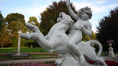 Lancut Sarayı 'nın güzel bahçelerinde yuva yapmış bir çocuk ve aslan tasvir eden çarpıcı klasik bir heykel..