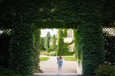 Polonya 'nın bahçeleri Lancut manzaralı sarmaşık kaplı kemerin altında bir çocuk..