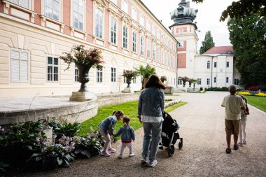 Lancut 'ta tarihi bir sarayda zarif bir açık hava bahçesini keşfeden bir grup insan.