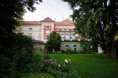 Resimli bahçe, sakin bir gökyüzünün altında tarihi bir Lancut binasını çerçeveliyor..