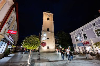 Rzeszow, Polonya - 22 Ağustos 2025: Rzeszow, Polonya 'nın büyüleyici gece manzarası, bir kule ve yayaların manzaranın keyfini çıkarması.