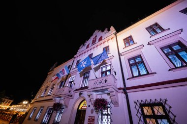 Rzeszow, Polonya - 22 Ağustos 2025: Geceleri Polonya 'nın Rzeszow kentinde bayraklı güzel aydınlatılmış tarihi bir bina.