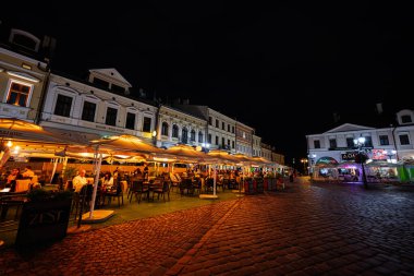 Rzeszow, Polonya - 22 Ağustos 2025: Aydınlık restoran terasları ve kaldırım taşı sokakları Rzeszow 'da sıcak bir akşam ortamı yarattı