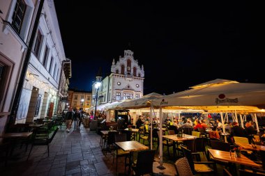 Rzeszow, Polonya - 22 Ağustos 2025: Açık hava yemekleri ve tarihi ışıklarla hareketli bir şehir meydanı manzarası