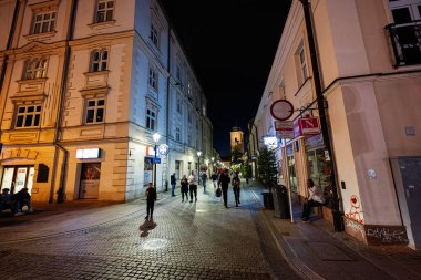 Rzeszow, Polonya - 22 Ağustos 2025: Polonya 'nın Rzeszow kentinde canlı gece caddesi, aydınlık binalar ve yürüyen yayalar.