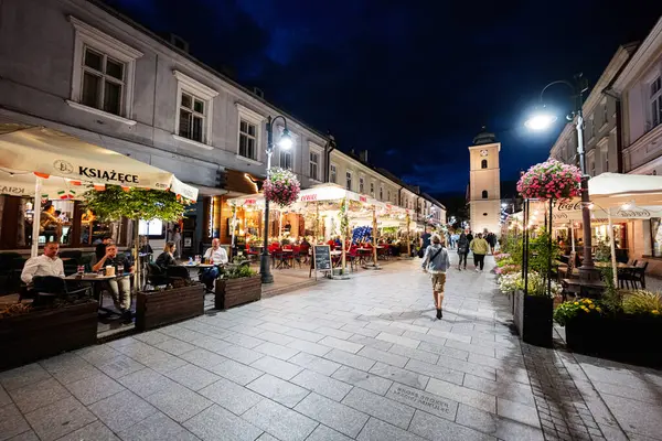 Rzeszow, Polonya - 22 Ağustos 2025: Rzeszow, Polonya 'daki yemek mekanları ve yayalarla samimi bir akşam manzarası