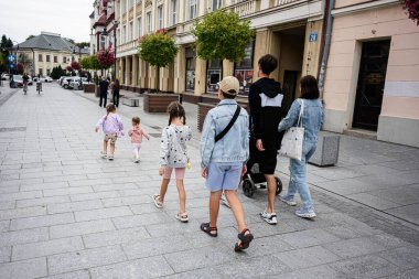 İnsanlar bulutlu bir günde Polonya 'nın Rzeszow şehrinde yaya bir sokakta geziniyorlar.