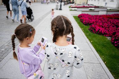 Oyuncak kameralı genç kızlar Polonya, Rzeszow 'da gezintiye çıkıyorlar.