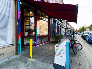 Manchester, İngiltere - 23 Eylül 2025: Manchester 'da bisiklet, tabela ve yeşillik ile canlı kentsel mağazalar dostça bir ortam yaratıyor.