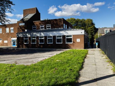 Manchester, İngiltere - 23 Eylül 2025: Manchester 'da kaldırım kenarındaki tuğladan bir kampüs binası.