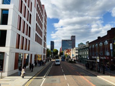 Manchester, İngiltere - 23 Eylül 2025: Manchester 'da modern mimari, şiir kütüphanesi, otobüsler ve sokak boyunca yaşayan insanlarla şehir sahnesi.
