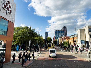 Manchester, İngiltere - 23 Eylül 2025: Yayalar, otobüsler, dükkanlar ve modern binalarla dolu Manchester caddesi manzarası.