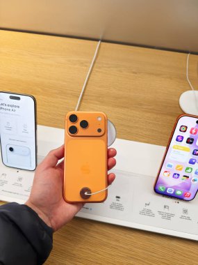 Manchester, İngiltere - 26 Eylül 2025: Orange iPhone 17 Pro bir teknoloji mağazasında sergilenmekte, diğer modeller yakınlarda görünür ve şarj edilmiş bir kablo
