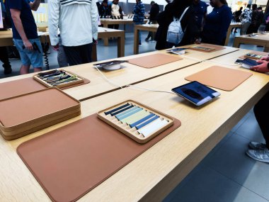 Manchester, İngiltere - 29 Eylül 2025: Alışverişçiler modern bir tasarım mağazası vitrininde deri rengi Apple Watch örnekleri ve dijital cihazları keşfediyorlar.