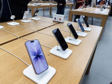 Manchester, İngiltere - 29 Eylül 2025: Meşgul bir perakende mağazasında müşterilerin keşfetmesi için hazır beyaz kaidede akıllı telefonlar iPhone 17.