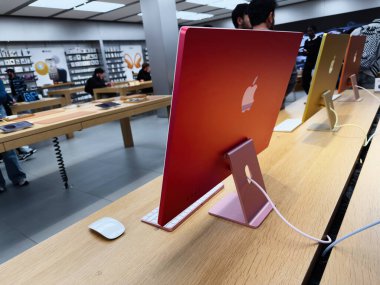 Manchester, İngiltere - 29 Eylül 2025: Teknoloji mağazasındaki ahşap bir masada Parlak Elma iMac, renkli stantlar ve arka planda müşteriler.