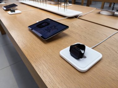 Manchester, İngiltere - 29 Eylül 2025: Modern teknoloji kurulumu Apple Watch Ultra 3 ve tableti ahşap bir masada test için hazır olarak gösteriyor.