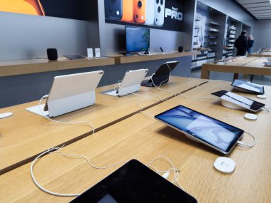 Manchester, İngiltere - 29 Eylül 2025: Modern iPad Air elektronik mağazası ahşap masalarda tablet ve akıllı telefonlar gösteriyor, müşterileri karşılaştırmaya davet ediyor.