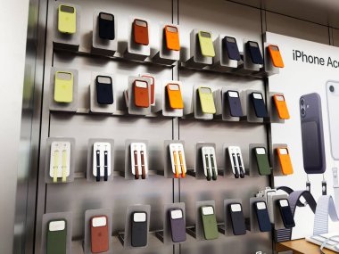 Manchester, İngiltere - 29 Eylül 2025: Bir mağaza duvarında çeşitli sergilenen iPhone 17 kutu ve aksesuarların renkli görüntüsü.