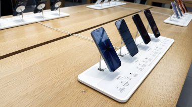 Manchester, İngiltere - 29 Eylül 2025: Bir perakende teknoloji mağazasında beyaz ekran üzerindeki iPhone akıllı telefonlar müşterileri ve vitrin modellerini davet ediyor.