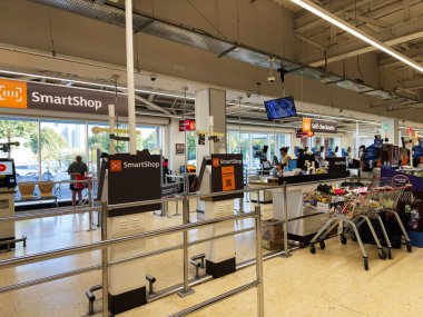 Salford, İngiltere - 25 Eylül 2025: Salford Sainsbury 'nin süpermarketinde self-servis ve kalabalık müşterilerle parlak bir sahne.