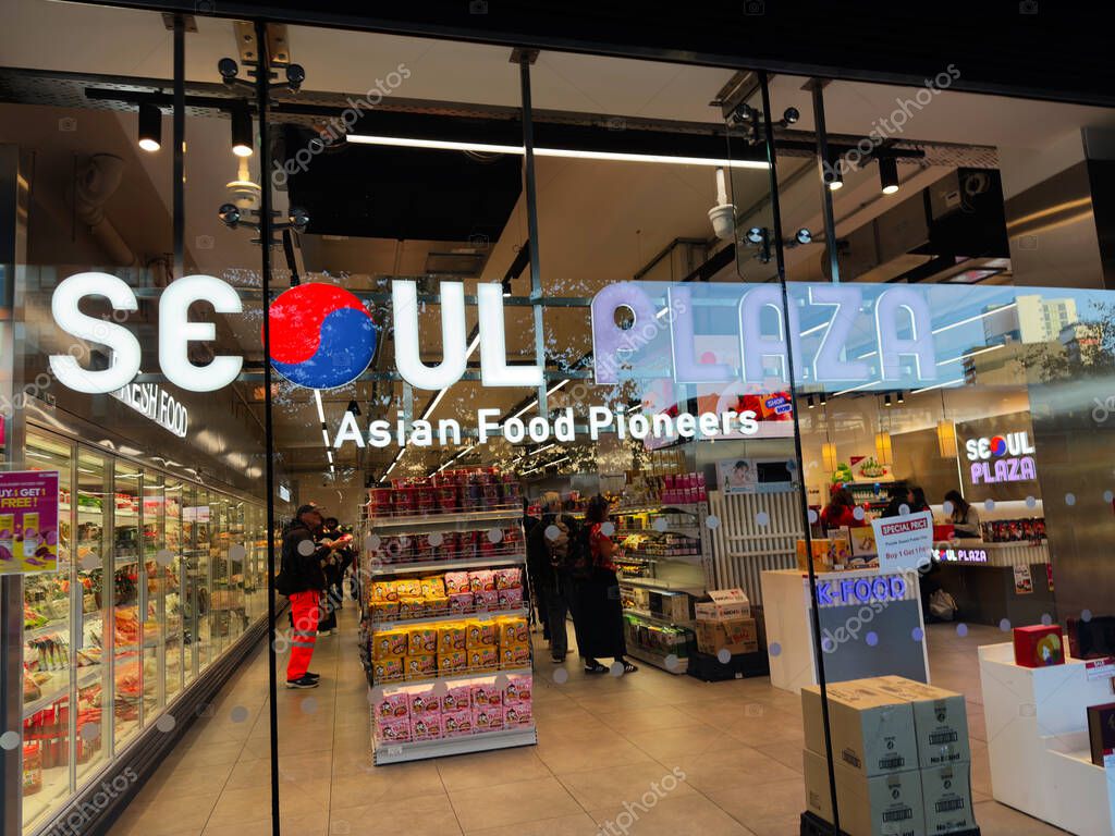 Manchester, UK - September 25, 2025: Vibrant Seoul Plaza storefront with Asian food offerings, glass doors, shoppers, and colorful product displays.