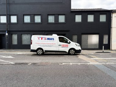 Manchester, İngiltere - 25 Eylül 2025: TTS Et Fabrikası logosu olan beyaz yemek kamyonu koyu tuğlalı bir binanın yanına park edilmiş..