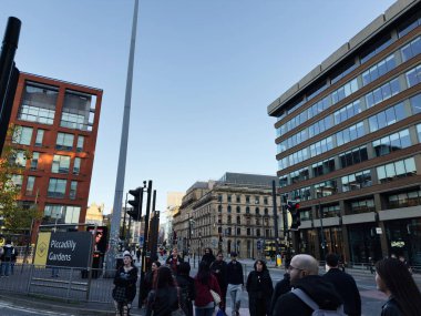 Manchester, İngiltere - 25 Eylül 2025: Piccadilly Gardens yakınlarındaki modern ve tarihi binaların karışımının yanında yayalar ve trafik işaretleriyle kalabalık Manchester şehri kavşağı.