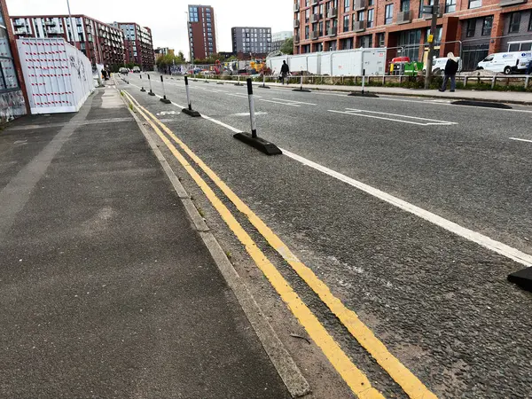 Manchester, İngiltere - 25 Eylül 2025: Manchester City caddesinde bariyerler, direkler ve yayalar ile yeni daireler yakınında inşaat çalışmaları.