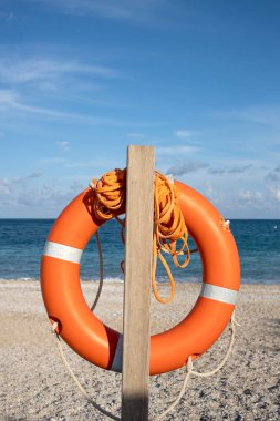 close-up of life ring hanging from post in front of the sea