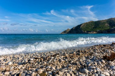 panoramic wave breaking on the shore of pebble beach