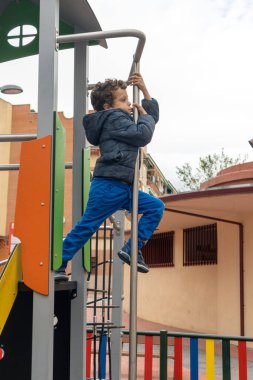 funny child on playground sliding down fireman's pole
