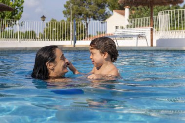 Anne ve oğlu havuzun keyfini çıkarıyor.