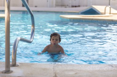Güzel çocuk yüzme havuzundan hoşlanıyor.