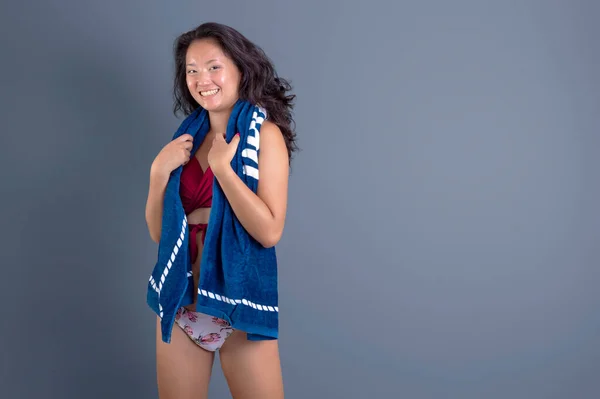 beauty asian ethnic woman in bikini with towel around her neck