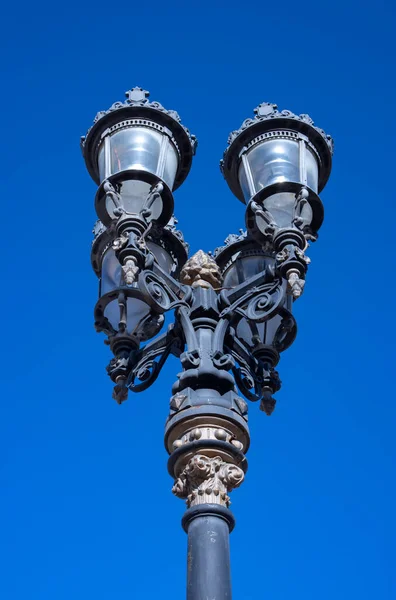 close up shot of old wrought iron street lamp, with four lamps