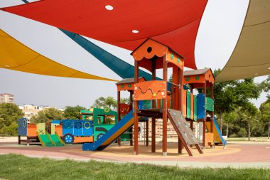 Korunaklı gölgeler altında canlı çocukların oyun parkı.