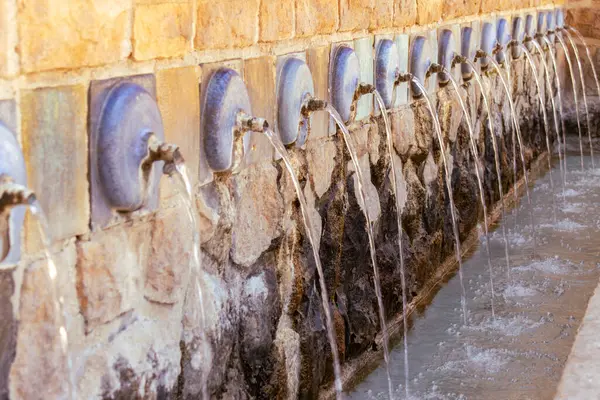 stock image Close-up of a historic stone fountain with multiple spouts in Polop, Spain.