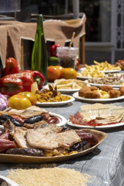 Açık hava yemek etkinliğinde servis edilen ızgara et, kroket, peynir, patates kızartması ve paella da dahil olmak üzere çeşitli İspanyol yemekleri..